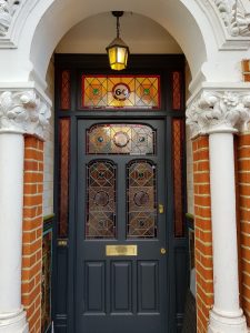 Traditional stained glass frontage with painted roundels for period property in south London.